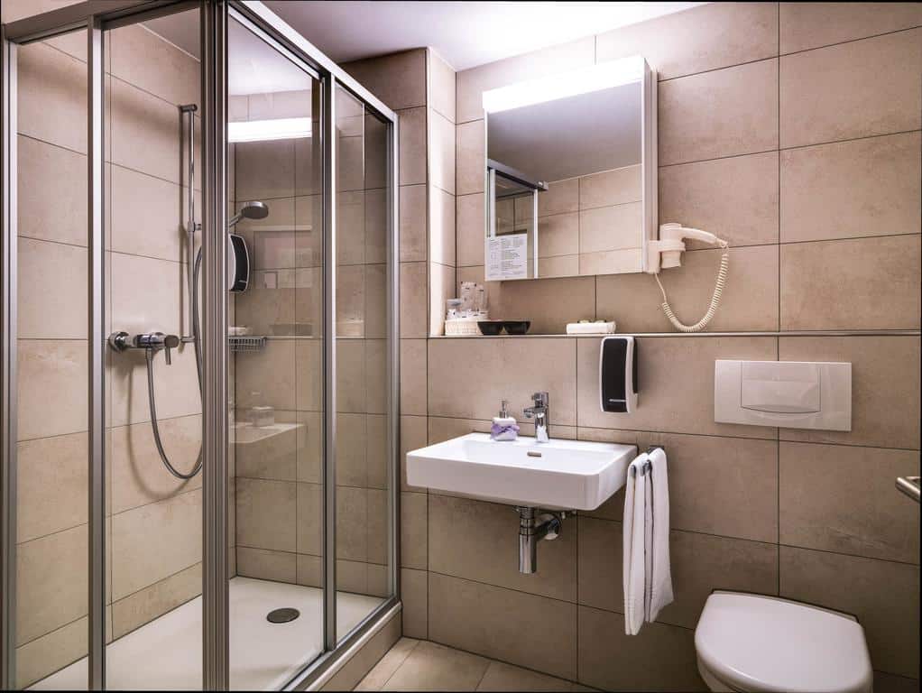 Clean tiled bathroom with walk-in shower and mirror