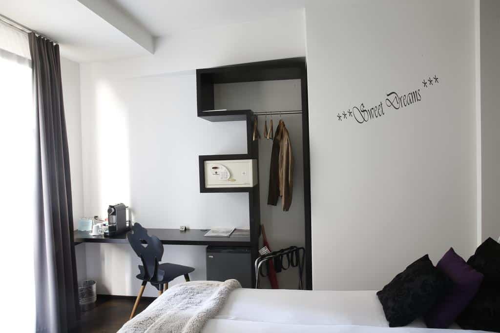 Minimalist hotel room with small desk and “Sweet Dreams” decor