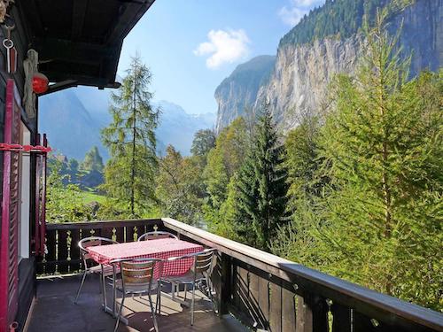 Balcony view of forest and mountains with outdoor table