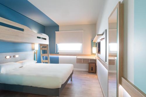 Minimalist hotel room with bunk bed and blue accent wall