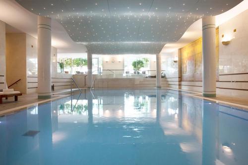 Indoor swimming pool with lounge chairs and a star-like ceiling design
