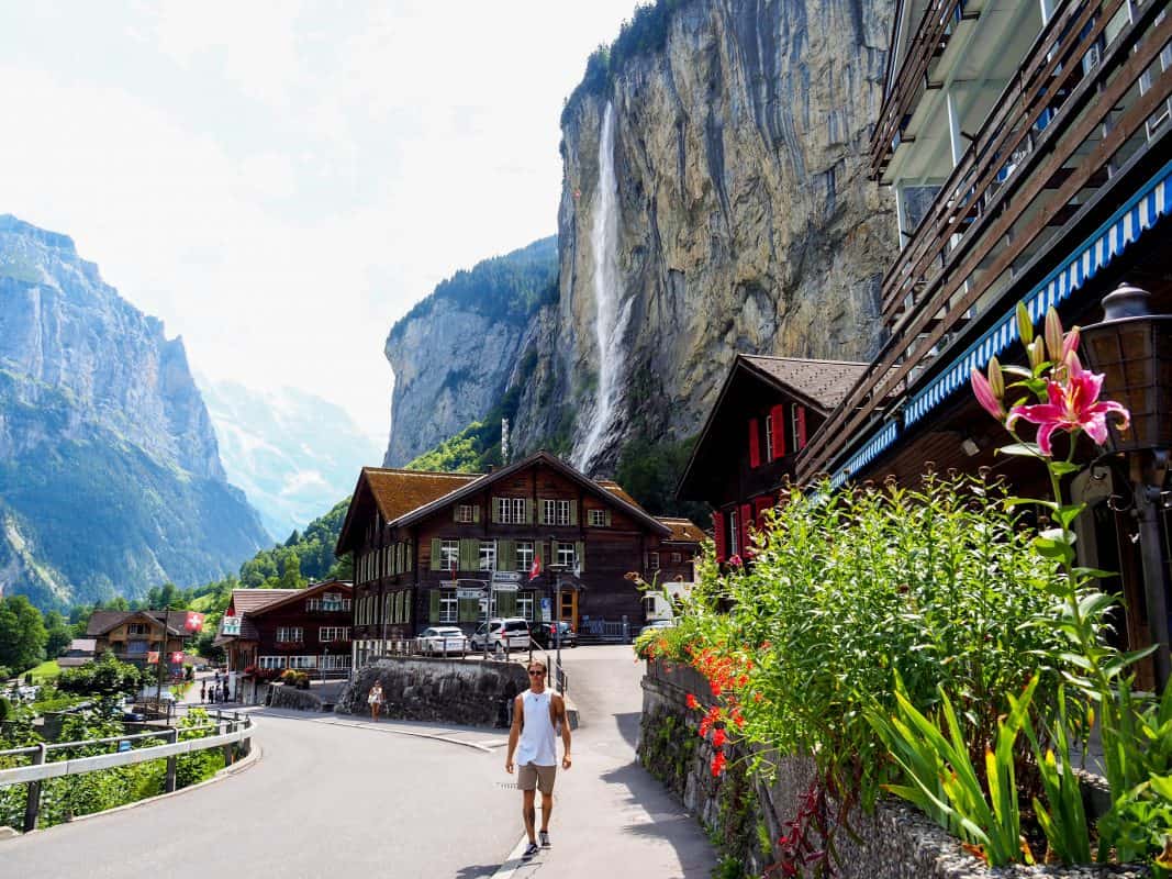Man walking in Lauterbrunnen village with Staubbach Falls