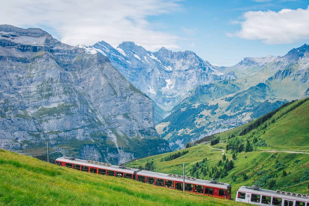 Lauterbrunnen village with the train to Jungfraujoch, trees and cliffs