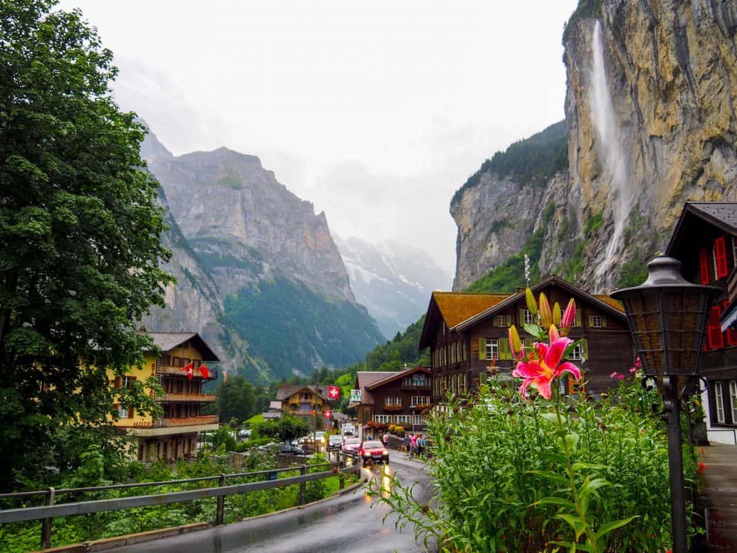 Lauterbrunnen village street with waterfall and mountain backdrop