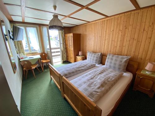 Wooden hotel room with green carpet and twin beds
